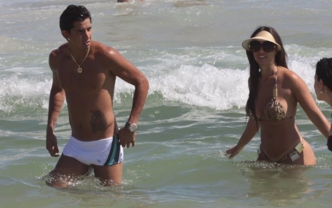 Nicole Bahls e namorado curtem praia